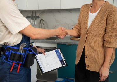 male-plumber-working-with-client-fix-kitchen-problems-scaled.jpg
